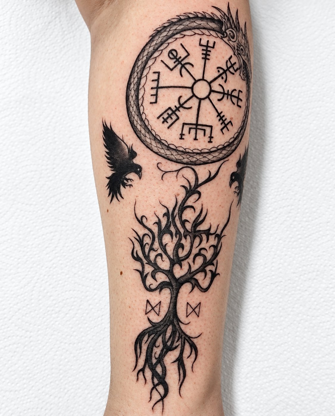 Tatuagem com símbolos nórdicos: vegvísir dentro de uma serpente, árvore da vida, corvos e runas